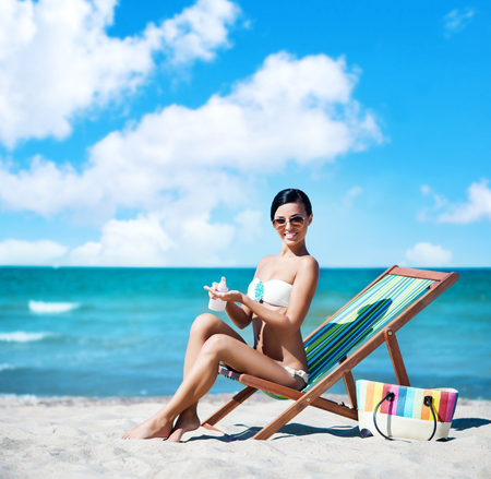 Beautiful, young, attractive girl in bikini taking a rest near the sea. Vacation, resort, holiday concept.の写真素材