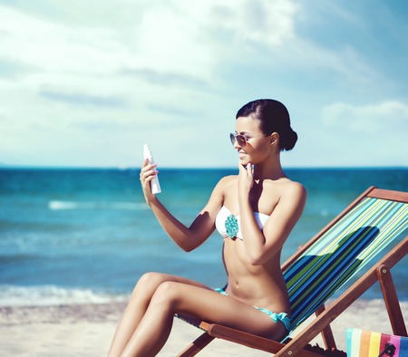 Attractive young girl in bikini sunbathing on beach. Traveling, holiday, vacation, concept.の写真素材