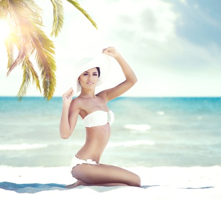 Young, attractive woman in sexy swimsuit relaxing on beach. Traveling, resort, vacation concept.の写真素材