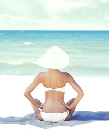 Young, attractive woman in sexy swimsuit relaxing on beach. Traveling, resort, vacation concept.の写真素材