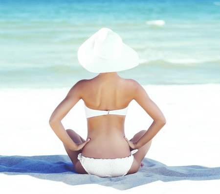 Beautiful, young, attractive girl in bikini taking a rest near the sea. Vacation, resort, holiday concept.の写真素材