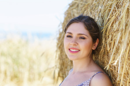 Young, emotional and happy woman in a meadow of rye. Beautiful girl in a white dress. Summer concept.の写真素材