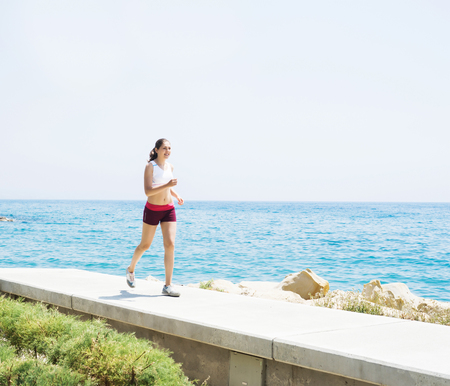 Fit and sporty woman training outside. Girl with a perfect body exercising outdoor.の写真素材