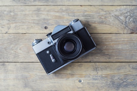 Vintage photo camera on a wooden background. Hipster style concept.の写真素材
