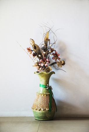Nice old-style green vase with decorative flowers.の写真素材