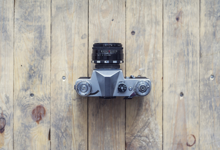Vintage photo camera over wooden background. Hipster style concept.の写真素材