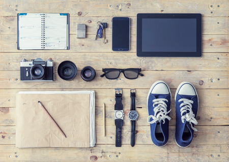 Outfit of a stylish traveler. Set of different objects and equipment: tablet, phone, album, glasses, camera, lenses, gumshoes and watches.の写真素材