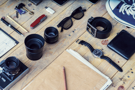 Outfit of a stylish traveler. Set of different objects and equipment: tablet, phone, album, glasses, camera, lenses, gumshoes, knife and watches.の写真素材