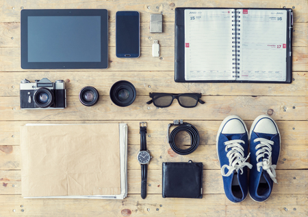 Outfit of a stylish traveler or a freelance journalist. Set of different objects and equipment: tablet, phone, album, glasses, camera, lenses, wallet, gumshoes, usb storage and watches.の写真素材