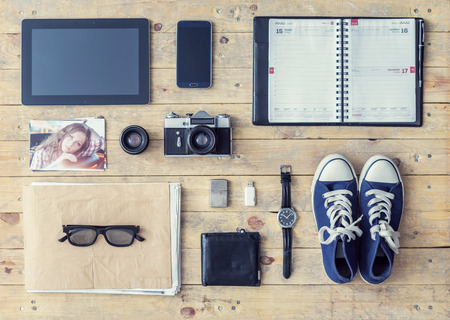 Outfit of a stylish photographer. Set of different objects and equipment: camera, lenses, tablet, phone, album, glasses, wallet, gumshoes, usb storage and watches.の写真素材
