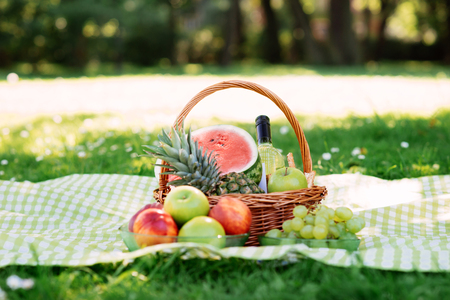 Romantic composition of a basket with fruits and wine in the park.の写真素材