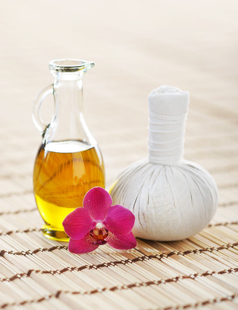 Spa aromatherapy composition with fragrant oil, orchid and ball on bamboo mat over isolated background.の写真素材