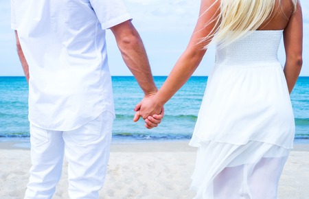 Loving couple walking and embracing on a tropical summer beachの写真素材