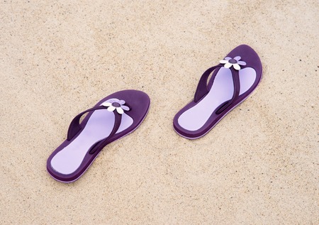 Close-up of beautiful, purple flip-flops on the sand.の写真素材