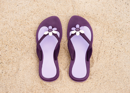 Close-up of beautiful, purple flip-flops on the sand.の写真素材