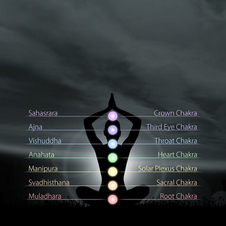 Silhouette of monk meditating in lotus position. Colored chakra lights over body. Yoga, zen, Buddhism, recovery, religion and wellbeing concept.の写真素材