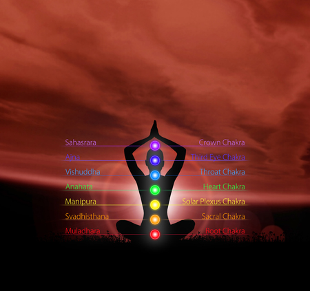 Silhouette of monk meditating in lotus position. Colored chakra lights over body. Yoga, zen, Buddhism, recovery, religion and wellbeing concept.の写真素材