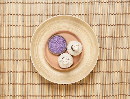 Massage bundle on a plate with bath salt over bamboo mat. Spa, health, treatment concept.の写真素材
