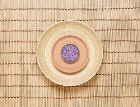 Plate with bath salt on bamboo mat. Health, treatment, spa concept.の写真素材