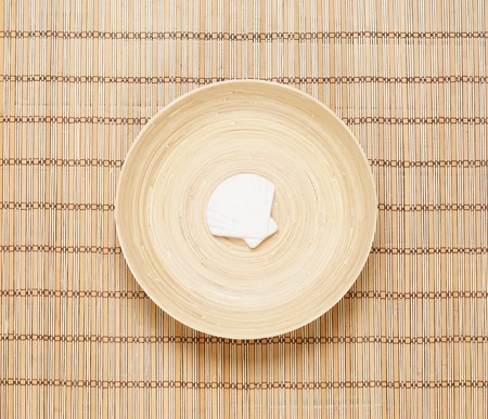 Seashell on a plate over bamboo mat. Health, spa, treatment concept.の写真素材