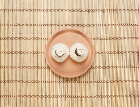 Massage bundles on a plate on bamboo mat. Spa, health, treatment, concept.の写真素材