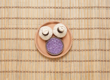 Massage bundle on a plate with bath salt over bamboo mat. Spa, health, treatment concept.の写真素材