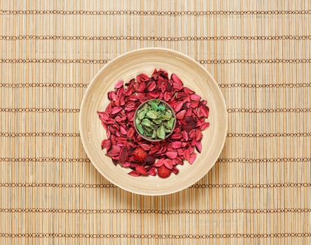 Plate with aroma petals on bamboo mat. Spa, beauty, treatment concept.の写真素材