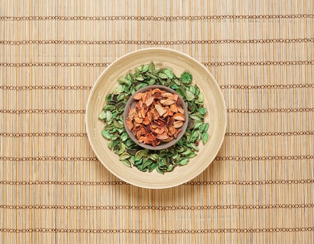 Plate with aroma petals on bamboo mat. Spa, beauty, treatment concept.の写真素材