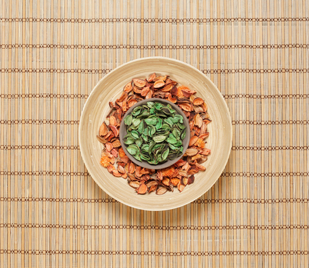 Plate with aroma petals on bamboo mat. Spa, beauty, treatment concept.の写真素材