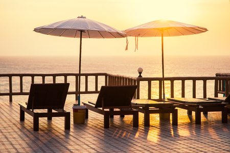 Terrace with a view on sea and the sunset. Umbrellas and lounge chair in a sunlight.の写真素材