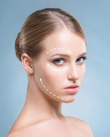 Close-up portrait of beautiful, fresh, healthy and sensual girl with arrows on her face. Medicine, spa and skin care concept.の写真素材