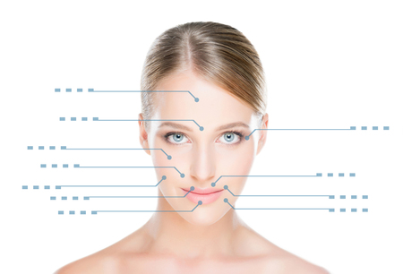 Close-up portrait of young, fresh and natural woman with the dotted arrows on her face pointing on a face areas.の写真素材