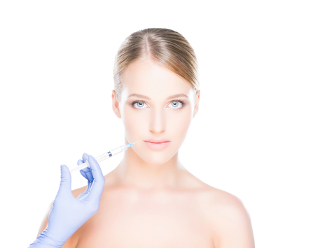 Doctor injecting in a beautiful face of a young woman. Plastic surgery concept.の写真素材