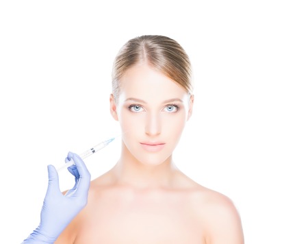 Doctor injecting in a beautiful face of a young woman. Plastic surgery concept.の写真素材