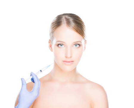 Doctor injecting in a beautiful face of a young woman. Plastic surgery concept.の写真素材