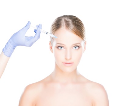 Doctor injecting in a beautiful face of a young woman. Plastic surgery concept.の写真素材