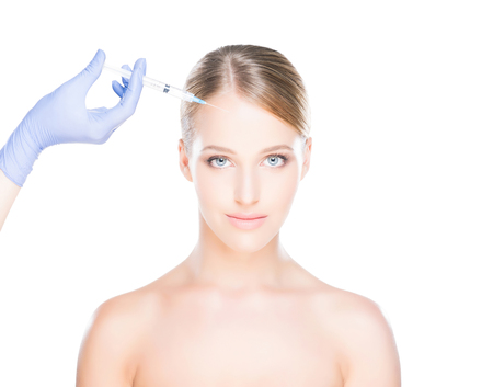 Doctor injecting in a beautiful face of a young woman. Plastic surgery concept.の写真素材