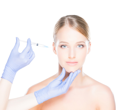Doctor injecting in a beautiful face of a young woman. Plastic surgery concept.の写真素材