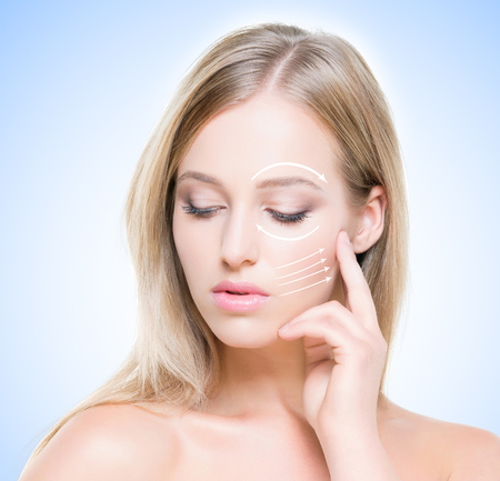 Portrait of attractive, young woman with pure and smooth skin over blue background. Plastic surgery concept.の写真素材