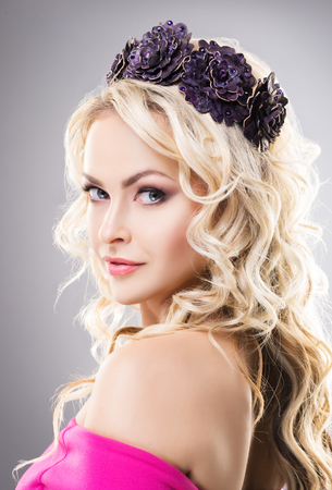 Close-up of gorgeous girl wearing pink dress and purple headband over grey background.の写真素材