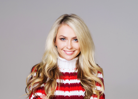 Portrait of young and beautiful woman in winter wear. Grey background. Christmas, xmas, x-mas concept.の写真素材