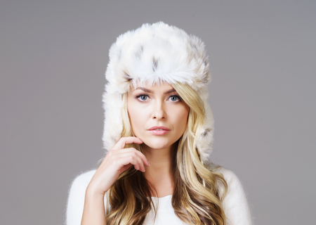 Portrait of young and beautiful woman in winter wear. Grey background. Christmas, xmas, x-mas concept.の写真素材