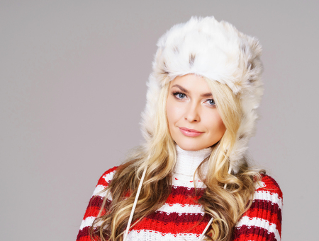 Portrait of young and beautiful woman in winter wear. Grey background. Christmas, xmas, x-mas concept.の写真素材