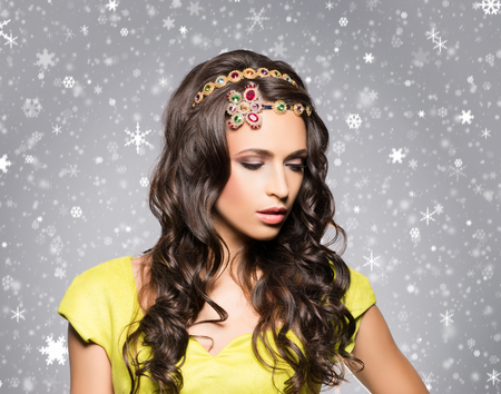 Beautiful brunette with luxury golden necklace over winter background. Christmas concept.の写真素材