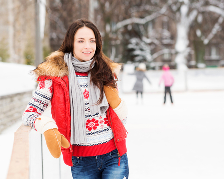 Young and pretty girl skating on outdoor open air ice rink at winter.の写真素材