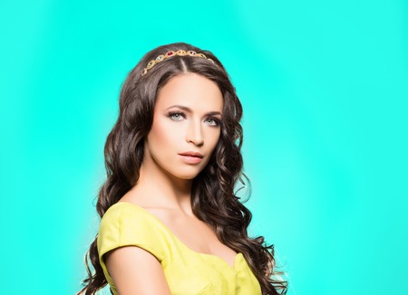 Portrait of beautiful brunette over cyan background. Beauty concept.の写真素材