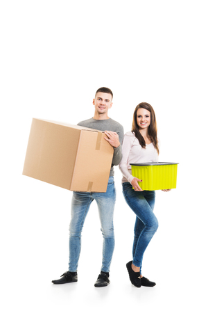 Young couple moving into a new home. Man and woman with boxes isolated on white.の写真素材