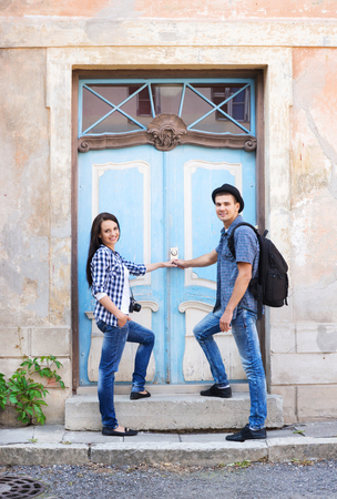 Young couple travelling, exploring new places and entering the door (hostel, hotel or appartments). Traveling and couchsurfing concept.の写真素材