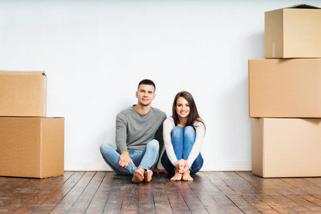 Young couple moving in a new home. Man and woman with boxes.
