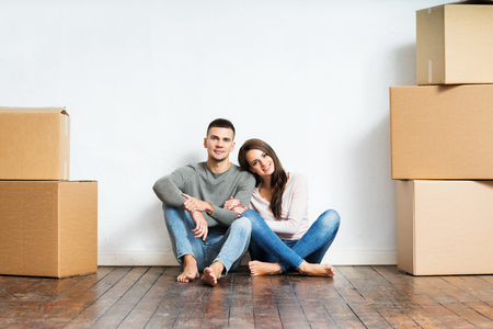 Young couple moving in a new home. Man and woman with boxes.の写真素材